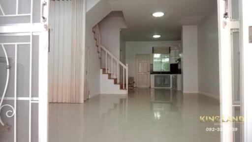 Spacious modern living area with tiled flooring and adjacent kitchen