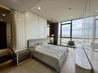 Modern bedroom with large windows and city view