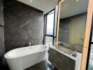 Modern bathroom with freestanding tub and large window