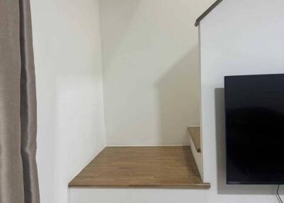 Staircase area next to living space with TV on stand