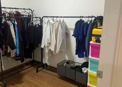 Spacious closet with hanging racks and storage bins