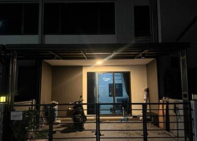 Exterior view of a building with a covered entrance and a gated fence