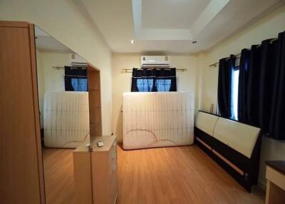 Bedroom with wooden flooring and window curtains