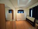 Bedroom with wooden flooring and window curtains