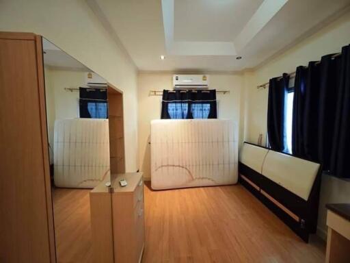 Bedroom with wooden flooring and window curtains