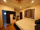 Spacious bedroom with double bed, wall-mounted TV, and en-suite bathroom