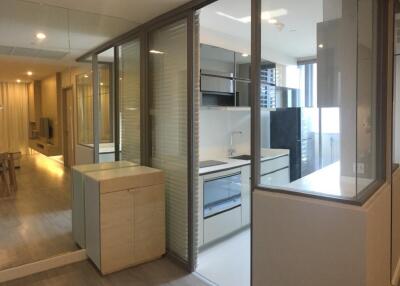 Modern kitchen adjacent to living space with large glass partitions