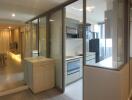 Modern kitchen adjacent to living space with large glass partitions