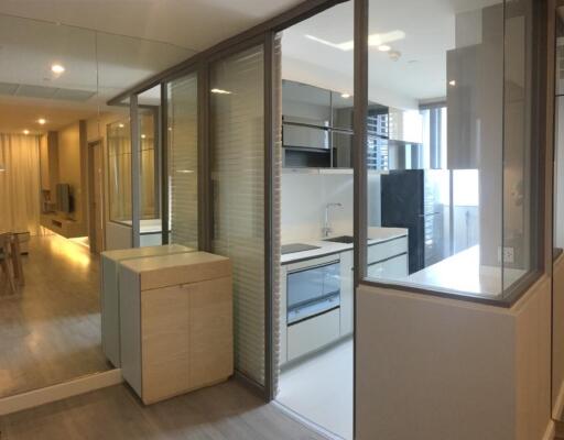 Modern kitchen adjacent to living space with large glass partitions