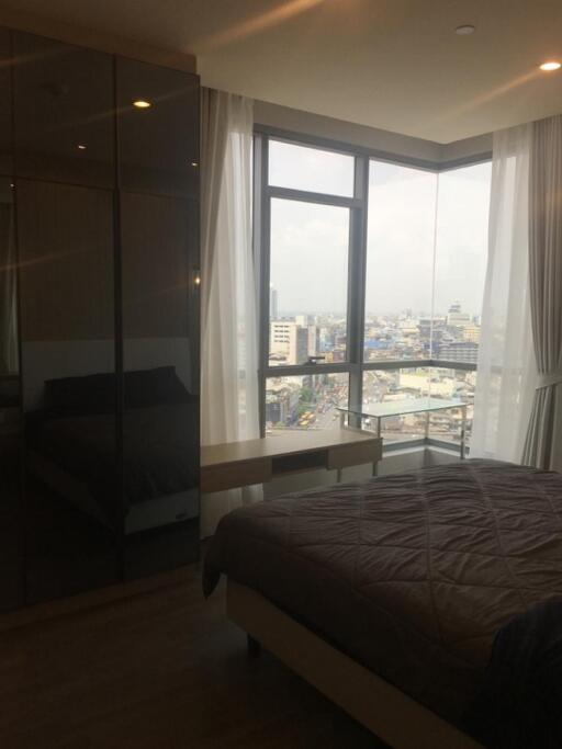 Bedroom with large window and city view