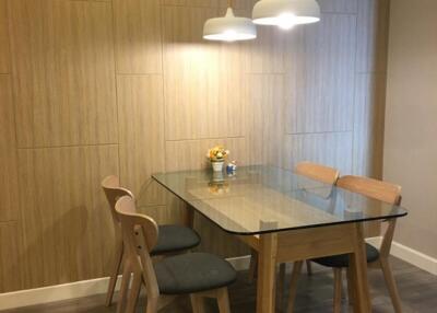 Modern dining area with glass table and wooden chairs