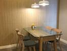 Modern dining area with glass table and wooden chairs