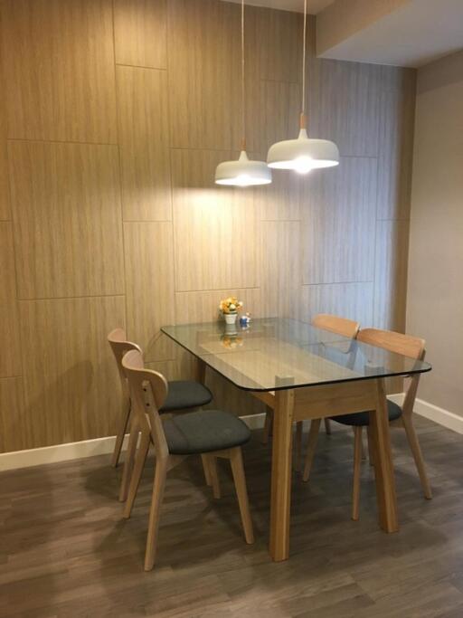 Modern dining area with glass table and wooden chairs