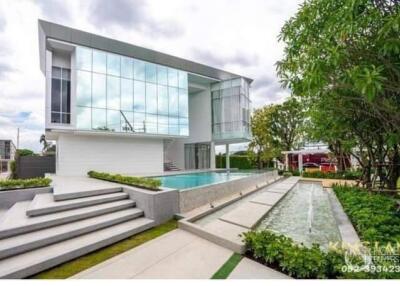 Modern two-story house with large windows and outdoor pool