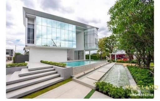 Modern two-story house with large windows and outdoor pool