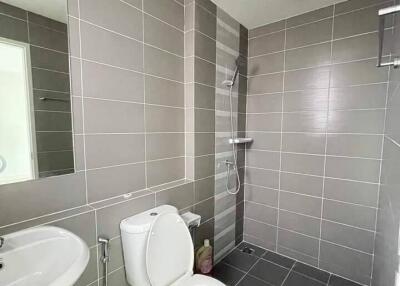 Modern bathroom with grey tiles, shower, and white fixtures