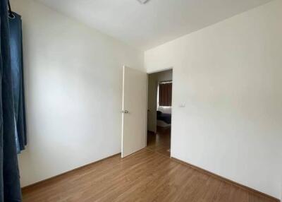 Simple empty bedroom with wooden floor and open door