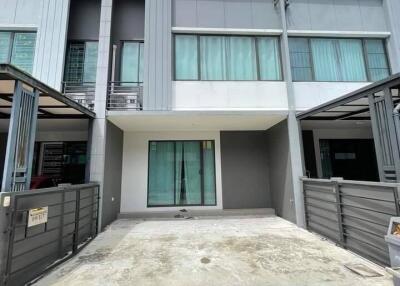 Two-story townhouse with a driveway and gated fence