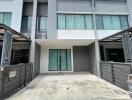 Two-story townhouse with a driveway and gated fence