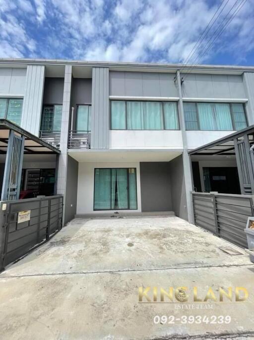 Two-story townhouse with a driveway and gated fence