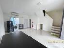 Main living area with a refrigerator, washing machine, staircase, and window