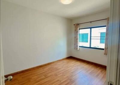 Empty bedroom with wooden floor and large window