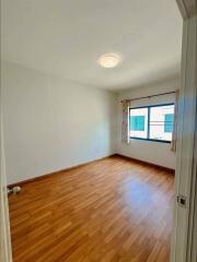 Empty bedroom with wooden floor and large window