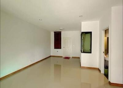 Spacious empty living room with glossy tiled floors and a doorway to additional rooms