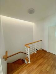 Modern staircase with wooden steps and white railing