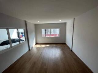 Spacious unfurnished room with large windows and wooden floor