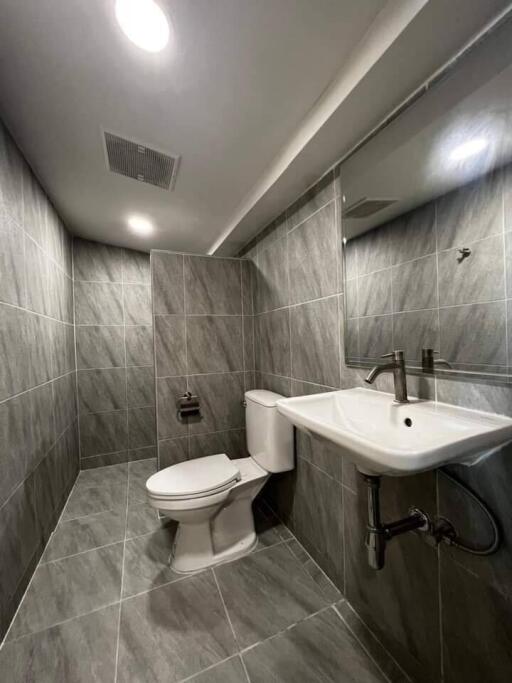 Modern bathroom with grey tile walls and flooring