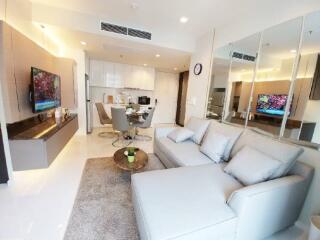 Modern living room with sectional sofa, dining table, and open kitchen