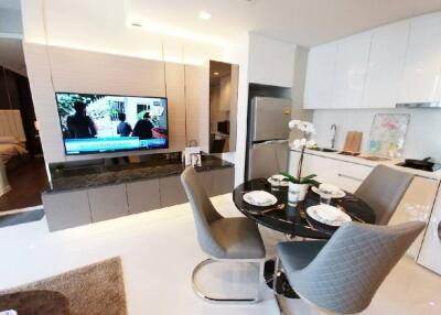 Modern living area with kitchen, dining table, and television