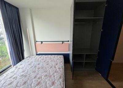 Bedroom with bed, open wardrobe, and window