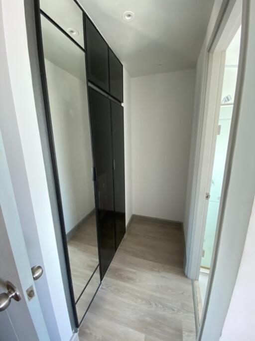 Narrow hallway with a mirrored wardrobe and wooden floor