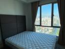 Bedroom with a large window and city view