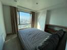 Bedroom with a large window providing city view