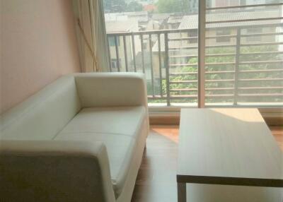 Living room with a white sofa and a coffee table near a large window