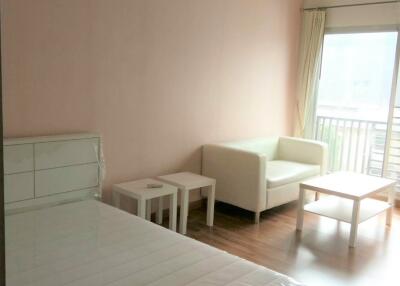 Bedroom with bed, small sofa, coffee table, and natural light