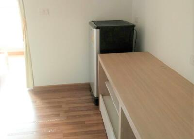 Compact kitchen area with wooden flooring and a refrigerator