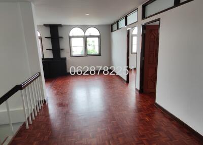 Spacious living room with hardwood flooring and large windows