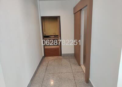 Small entrance hallway with a view of a kitchen through an open door