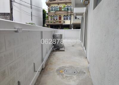 Narrow outdoor area with concrete flooring and electrical unit