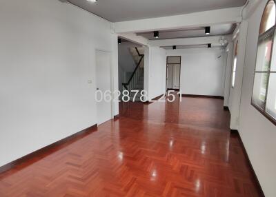 Spacious living area with wooden flooring and large windows