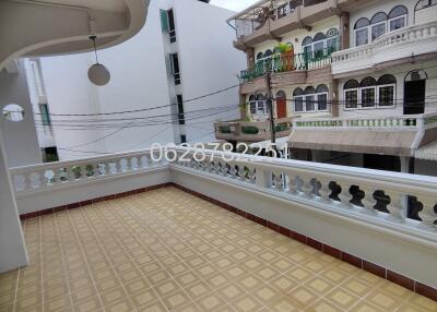 Spacious balcony with a tiled floor and a view of neighboring buildings