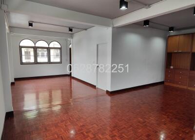 Spacious living room with wooden flooring and large windows