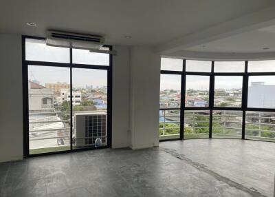 Spacious living room with large windows offering city views