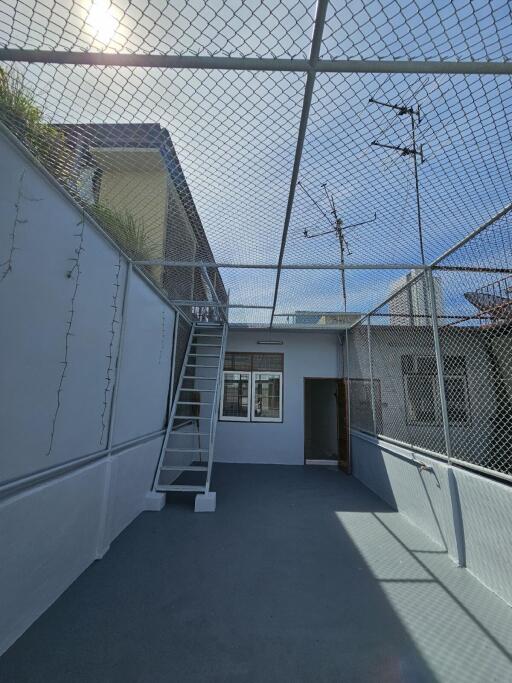 Gated outdoor area with stairs and antenna