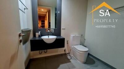 Modern bathroom with a sink, toilet, and mirror