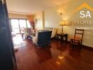 A spacious and well-lit living room with wooden flooring